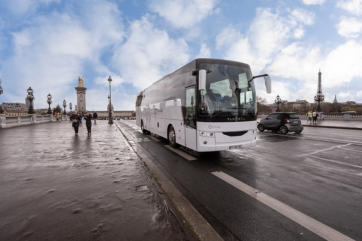 Autocar de tourisme traversant Paris, service de voyage organisé en Europe"